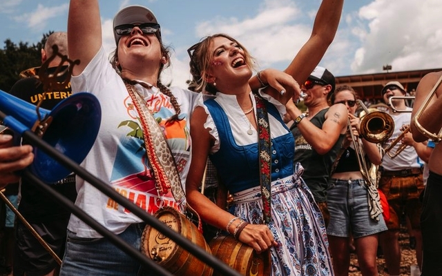 Menschen feiern in Trachten auf dem Woodstock der Blasmusik Festival.