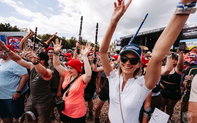 Menschen feiern vor einer Open-Air-Bühne beim Woodstock der Blasmusik Festival.