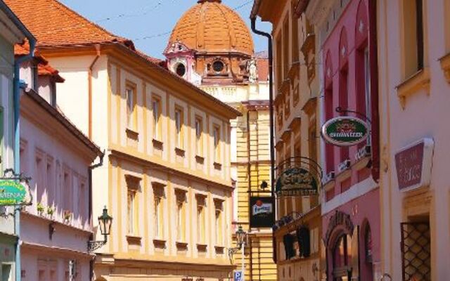 Menschen spazieren durch eine malerische Fußgängerzone in einer Altstadt.