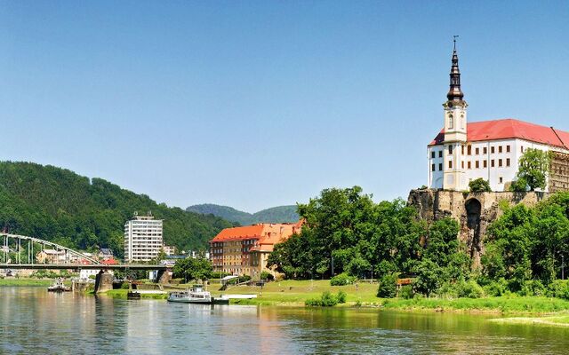 Stadtansicht mit Schloss auf einem Hügel und Fluss im Vordergrund