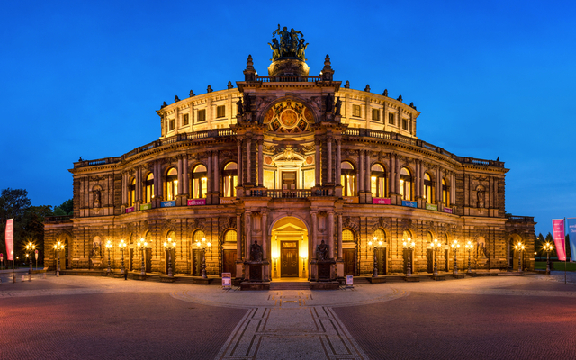 Panoramaaufnahme der Semperoper in Dresden bei Nacht, beleuchtet mit klarem Himmel im Hintergrund.
