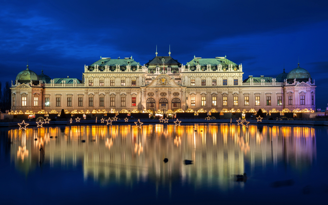 Das Obere Belvedere bei Nacht mit Lichterdekoration und Spiegelung im Wasser.