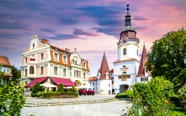 Malerische Altstadt mit Kirche und historischem Gebäude bei Sonnenuntergang.